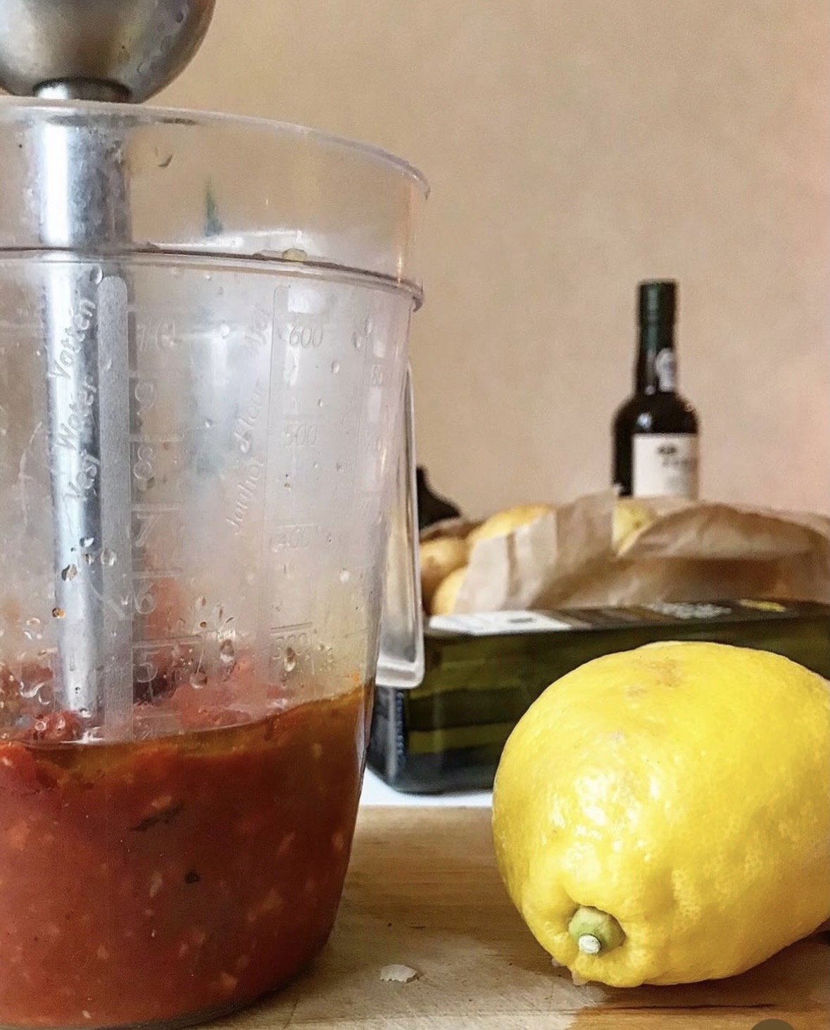 Nymixad piri-piri-marinad i mixerkanna med stavmixer, bredvid en citron på skärbräda