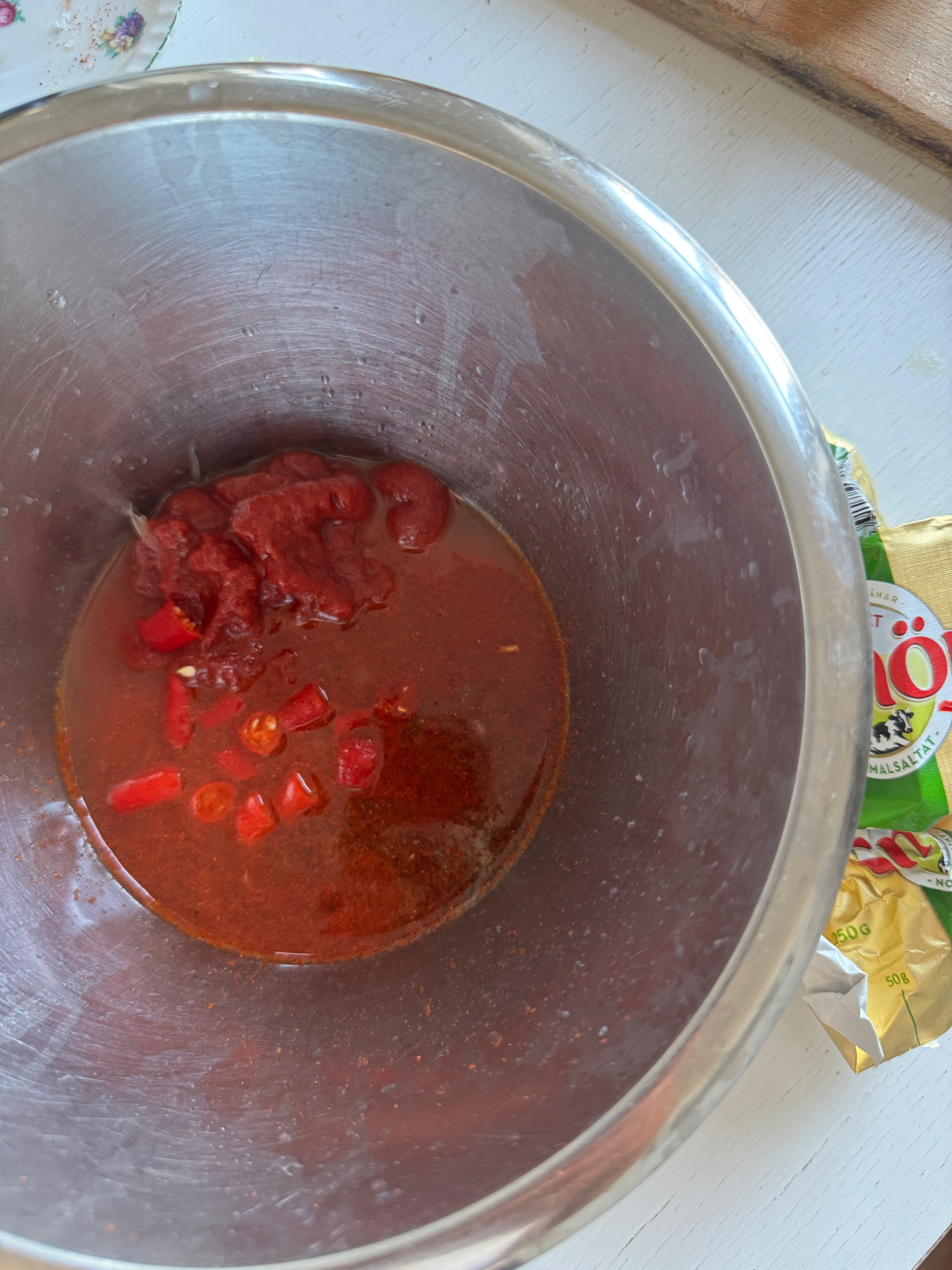 Marinaden rörs ihop: tomatpuré, färsk chili, paprikapulver och olivolja i en stålskål