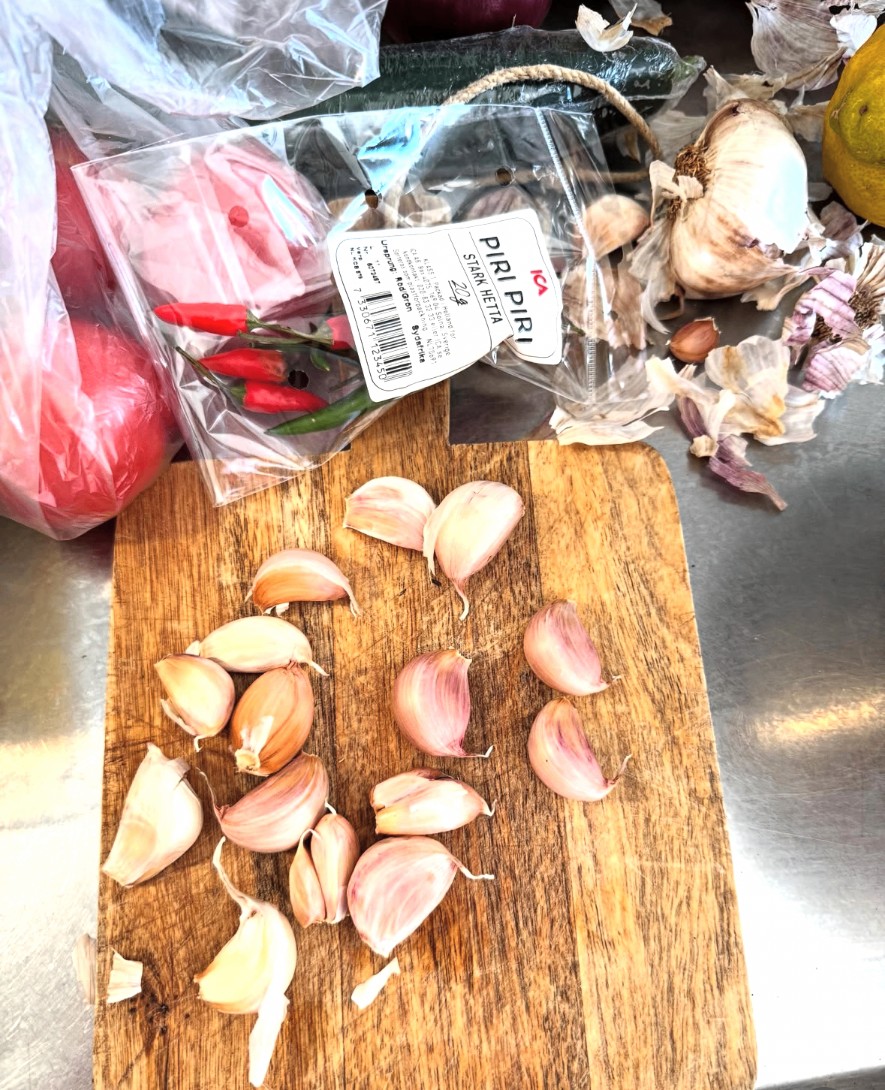 Vitlök och piri-piri på skärbräda med olivolja