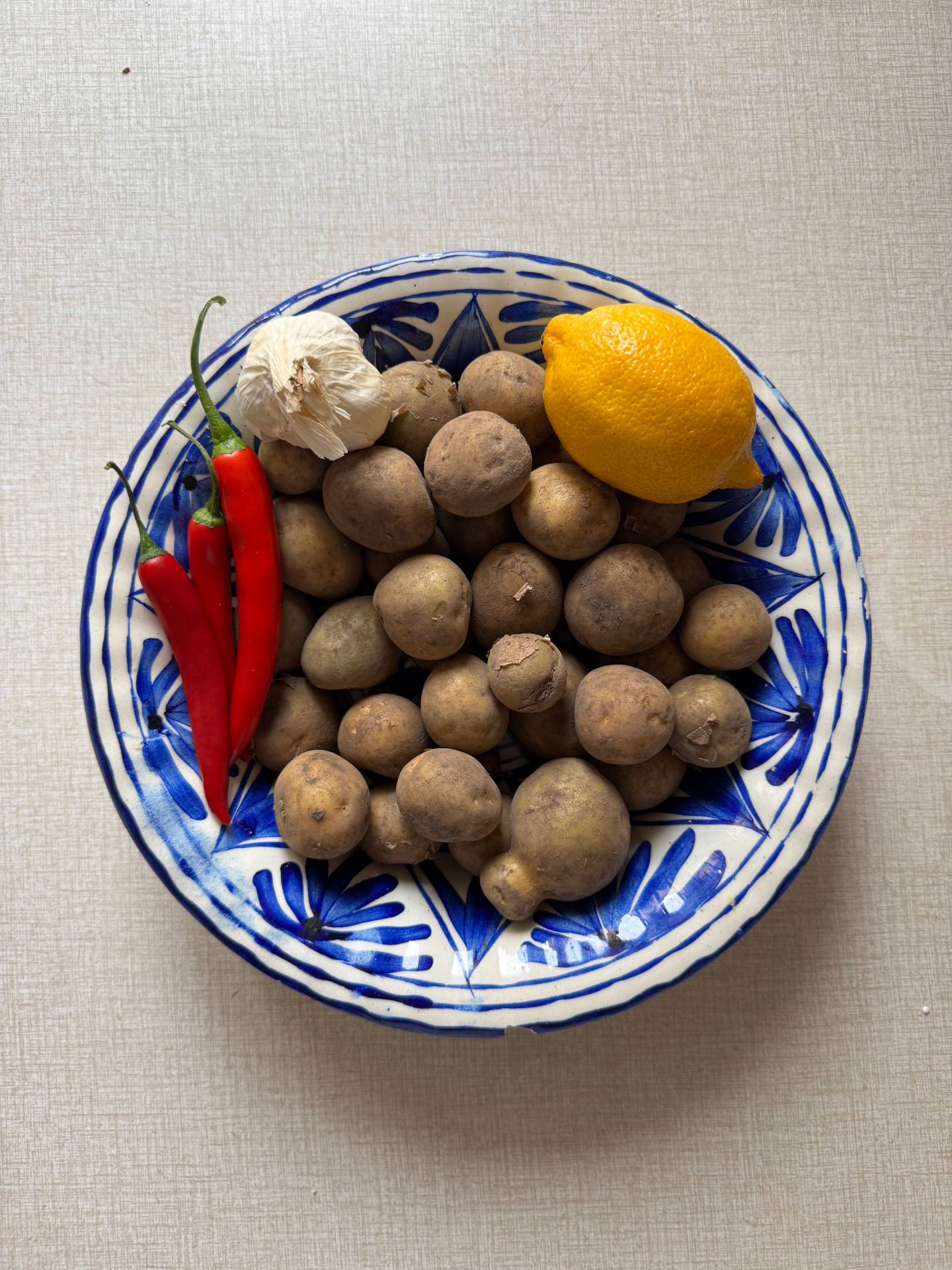 Färskpotatis, vitlök, chili och citron i en blå-vit portugisisk skål
